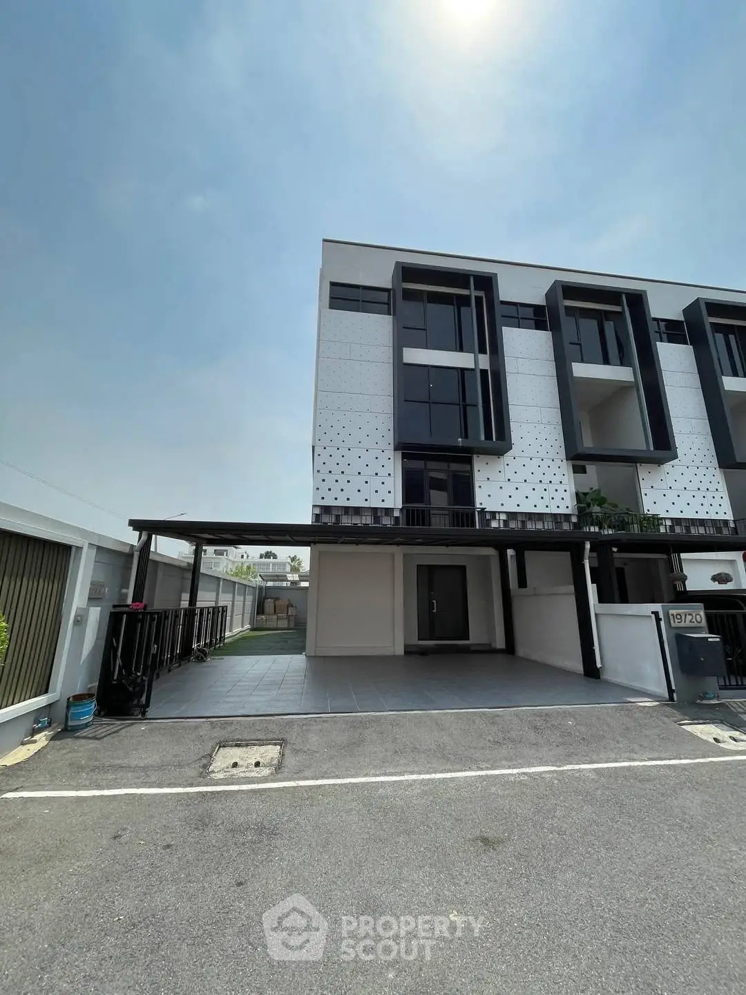 Modern three-story townhouse with sleek facade and spacious driveway