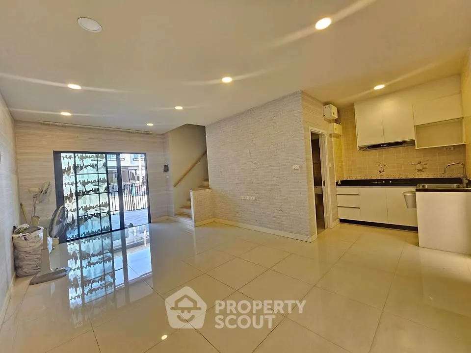 Spacious open-plan living area with modern kitchen and large windows