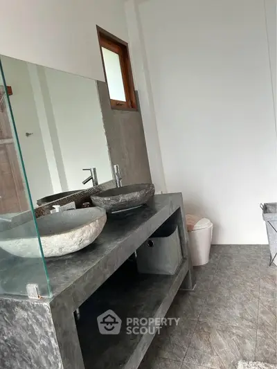 Modern bathroom with dual stone sinks and sleek gray countertop