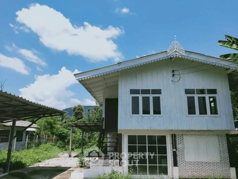 Charming two-story house with rustic design and scenic mountain backdrop.