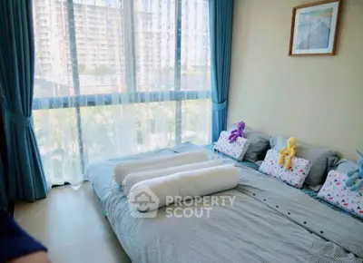 Bright and cozy bedroom with large window and modern decor in urban apartment.