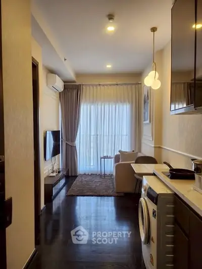 Modern living room with washing machine and open layout, featuring elegant lighting and cozy seating area.