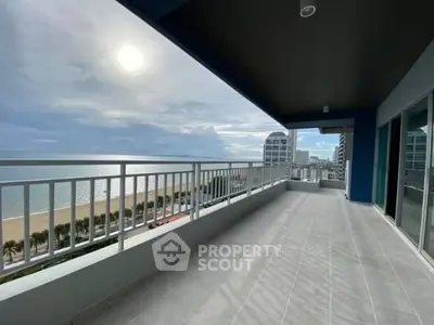 Spacious balcony with stunning ocean view in modern high-rise building.