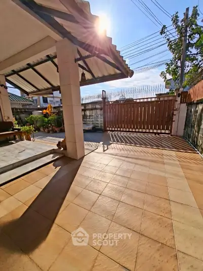 Spacious outdoor patio with tiled flooring and gated entrance, perfect for relaxation and security.
