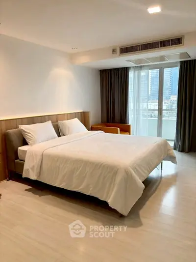 Spacious modern bedroom with large window and city view