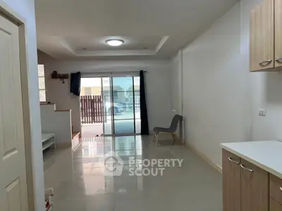 Spacious open-plan living area with sliding glass doors and modern lighting