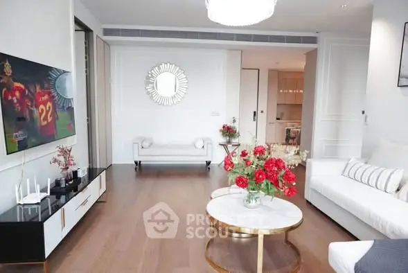 Elegant living room with modern decor and stylish furniture, featuring a large wall-mounted TV and chic coffee table.