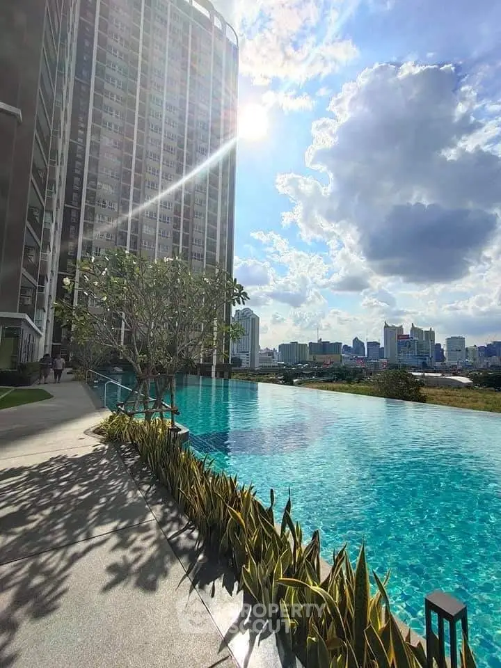 Luxurious high-rise building with stunning pool and city skyline view.