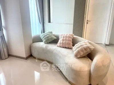 Elegant modern living room with stylish curved sofa and plush pillows, perfect for relaxation and comfort.