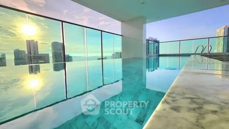 Stunning rooftop infinity pool with panoramic city skyline views at sunset.