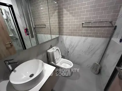 Modern bathroom with sleek design, featuring a stylish sink and elegant tile work.