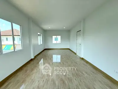 Spacious empty room with large windows and glossy wooden flooring, perfect for customization.