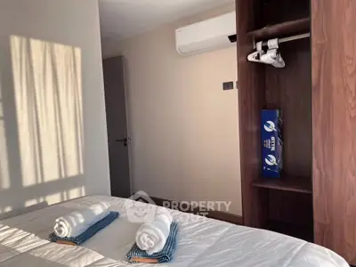 Cozy bedroom with air conditioning and wooden wardrobe, perfect for relaxation.