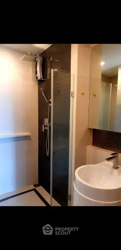 Modern bathroom with sleek shower and stylish sink in contemporary apartment.