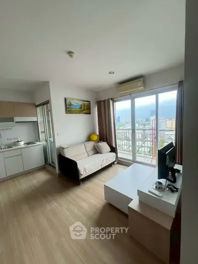 Modern living room with city view, featuring sleek furniture and large windows for natural light.