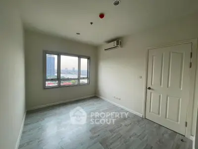 Spacious empty room with large window and city view, ideal for customization.