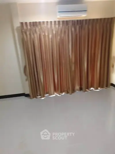 Spacious room with air conditioning and elegant curtains, perfect for comfortable living.
