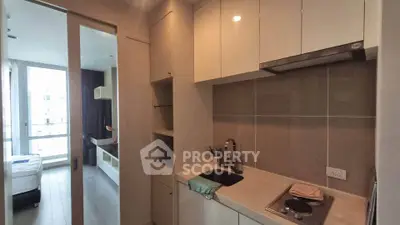 Modern compact kitchen with sleek cabinetry and integrated appliances in a stylish apartment.