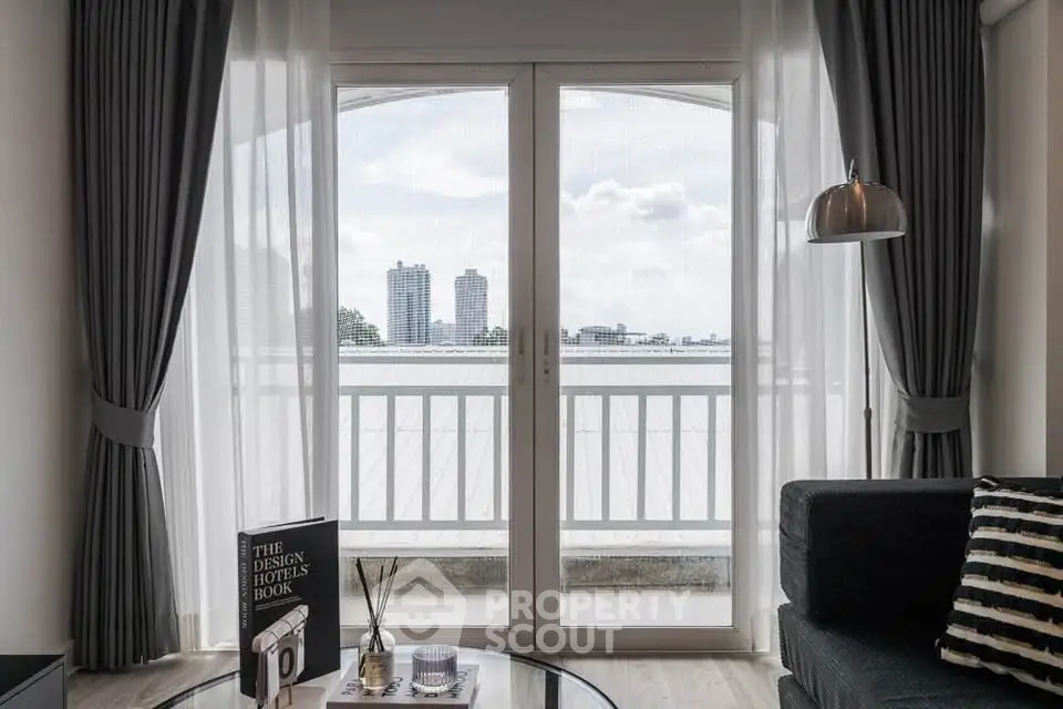 Stylish living room with large windows and city view, featuring modern decor and cozy ambiance.