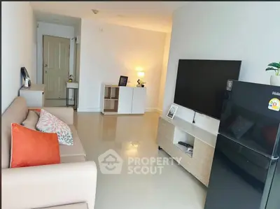 Modern living room with sleek furniture and large TV, perfect for relaxation and entertainment.