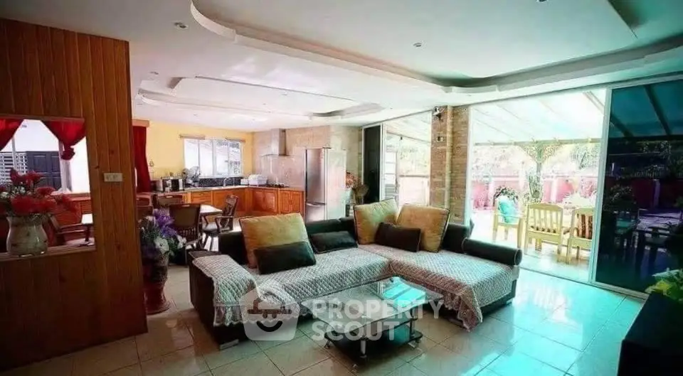 Spacious open-layout living room with modern kitchen and garden view