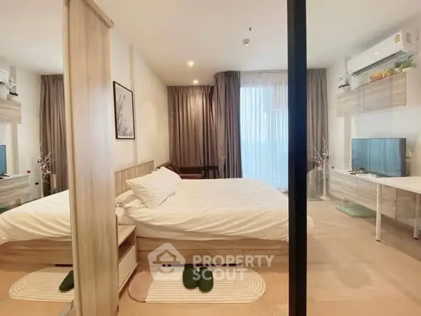 Modern bedroom with cozy decor and natural light, featuring a stylish bed and elegant curtains.