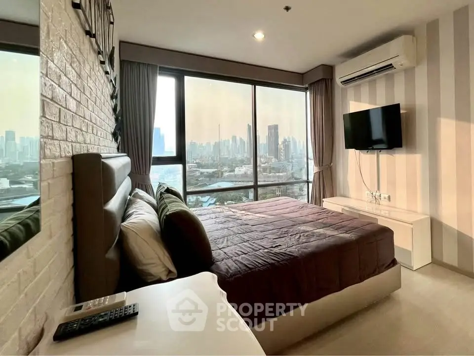 Modern bedroom with city view, featuring large windows, stylish decor, and air conditioning.
