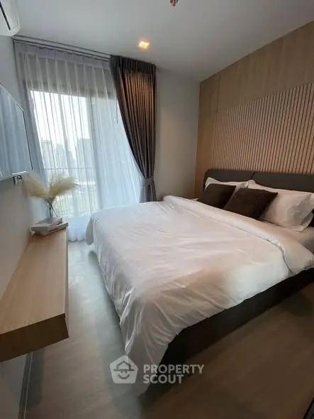 Cozy modern bedroom with large window and elegant decor