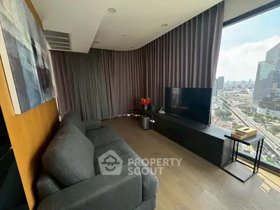 Modern living room with city view, featuring sleek furniture and floor-to-ceiling windows.