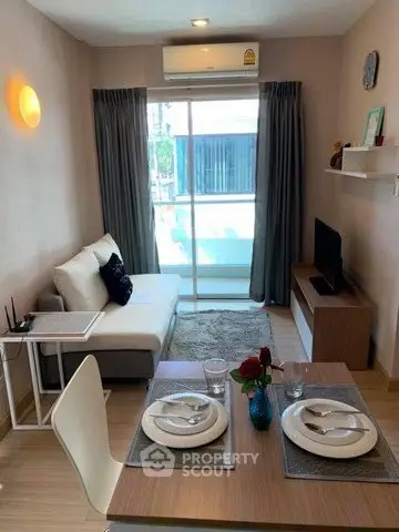 Cozy living room with modern decor and dining area, featuring a large window for natural light.