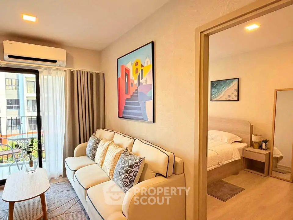 Modern living room with cozy sofa and stylish decor adjacent to a serene bedroom in a bright apartment.