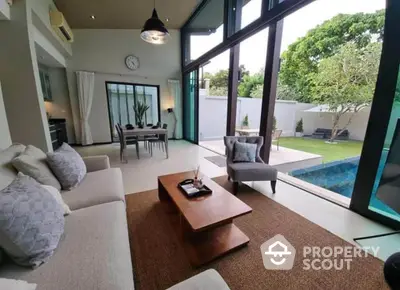 Luxurious living room with pool view and modern decor in a spacious open layout.