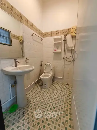 Compact bathroom with modern fixtures and tiled flooring, featuring a shower and toilet.