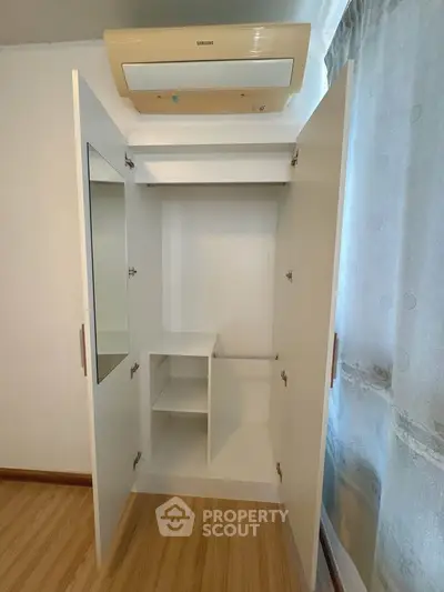 Spacious wardrobe with mirror and air conditioning in modern apartment