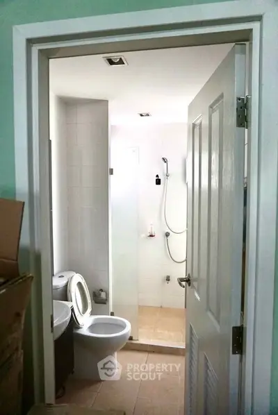 Modern bathroom with shower and toilet in a compact layout, ideal for efficient space utilization.