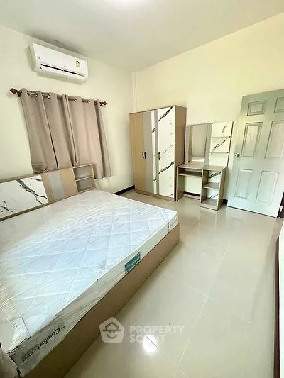 Spacious bedroom with modern furniture and air conditioning, perfect for comfort and relaxation.