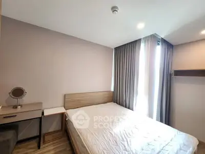 Cozy bedroom with natural light and modern furnishings in a stylish apartment.