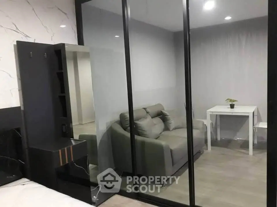 Modern apartment with glass partition, cozy living area, and stylish decor.