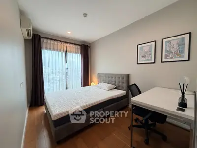 Modern bedroom with city view, featuring a comfortable bed, desk, and stylish decor.