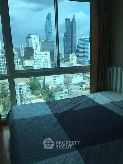 Stunning city view from a modern bedroom window in a high-rise apartment.