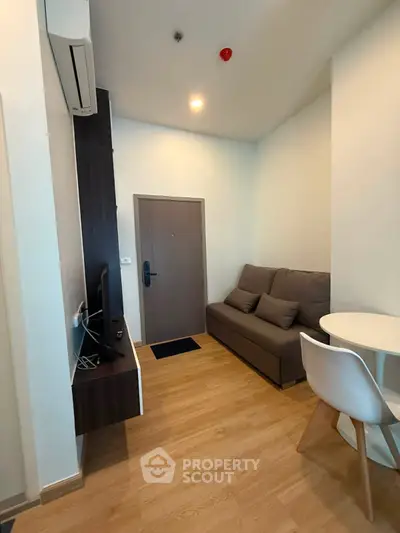 Modern living room with sleek furniture and wooden flooring in a cozy apartment.