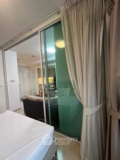 Modern apartment interior with sliding glass doors and elegant curtains