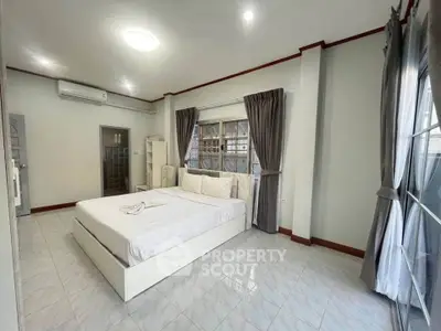 Spacious bedroom with large windows and modern decor for sale