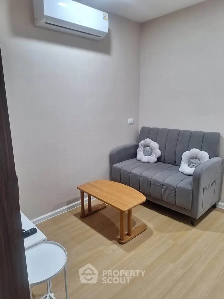 Cozy living room with modern sofa and air conditioning, perfect for relaxation.