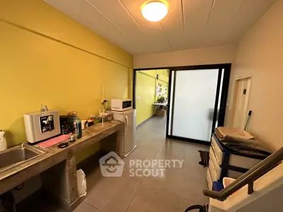 Compact kitchen area with concrete countertop and small fridge in modern apartment.