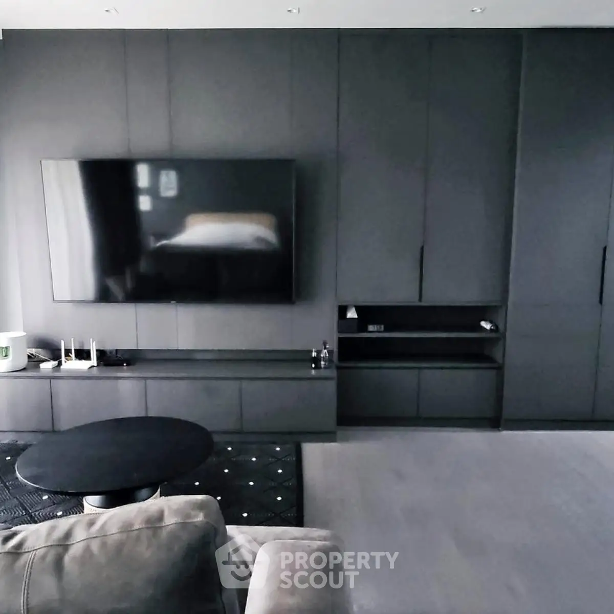 Modern living room with sleek black cabinetry and large flat-screen TV, perfect for entertainment.