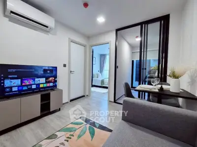 Modern living room with sleek decor and open layout, featuring a TV and dining area.
