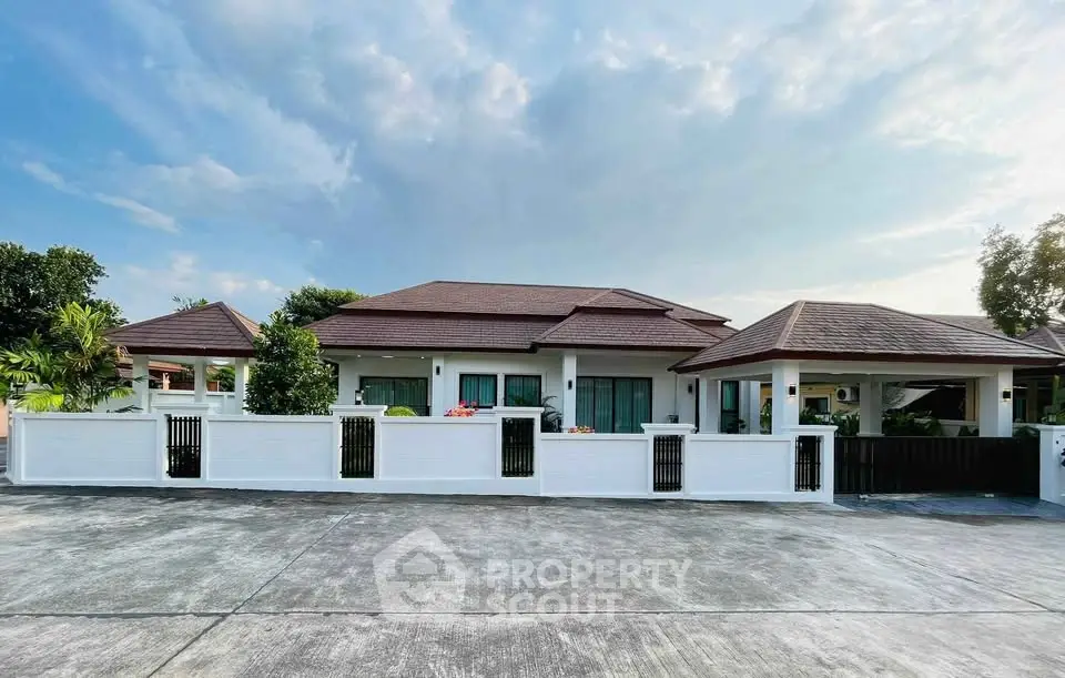 Stunning modern house with spacious driveway and elegant architecture under a clear sky.