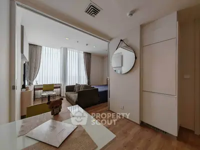 Modern open-plan living room with stylish decor and natural light, featuring a cozy seating area and dining space.