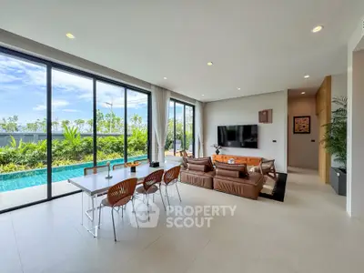 Luxurious open-plan living room with pool view and modern furnishings